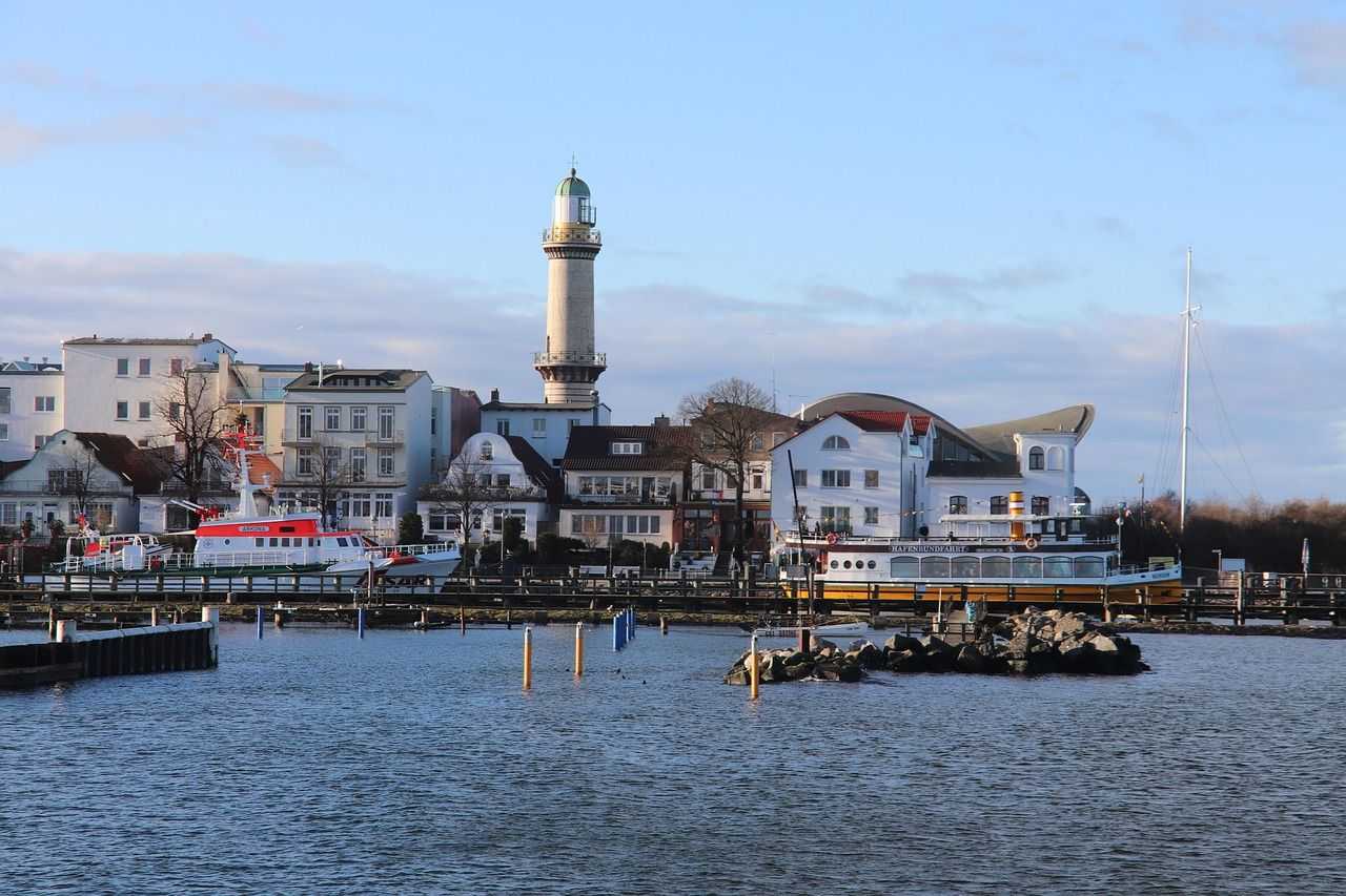 Blick vom Wasser auf den Leuchtturm und den Teepott in Warnemünde