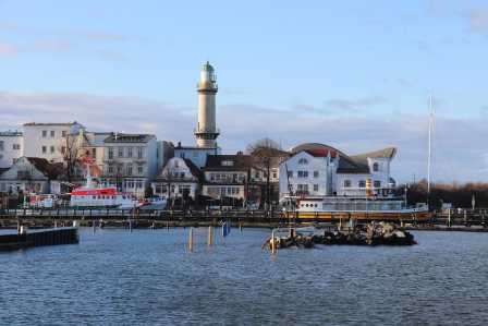 Blick vom Wasser auf den Leuchtturm und den Teepott in Warnemünde